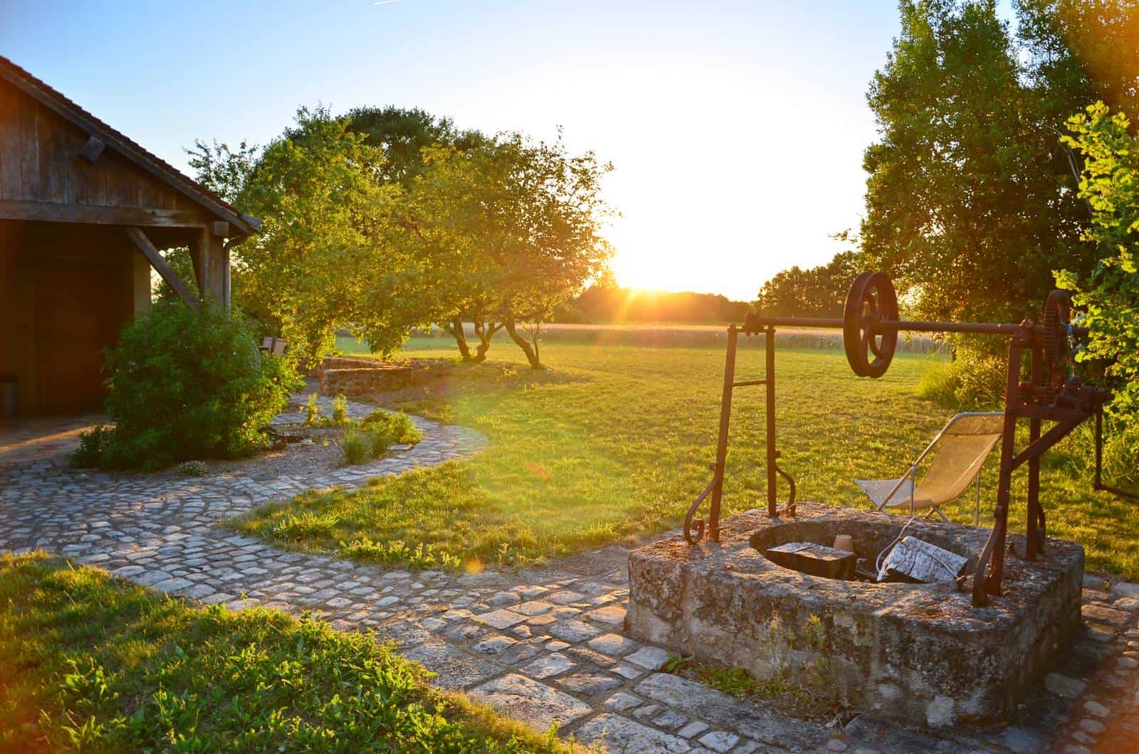 Vieux puits à l'entrée de la pelouse au coucher de soleil - gîte rural de Haute Forêt en Vallée du Loir